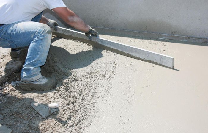 worker in the midst of fresh cement