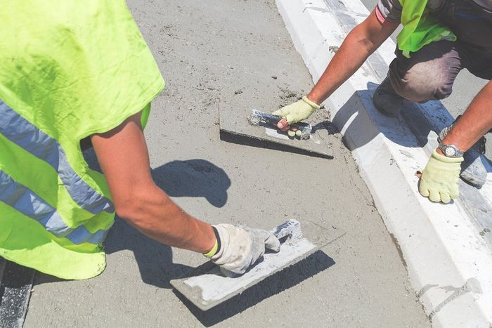 workers are falttens the fresh concrete